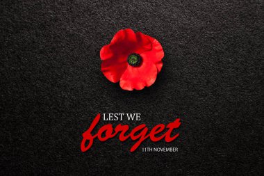 The remembrance poppy - poppy appeal. Poppy flower on black textured background. Decorative flower for Remembrance Day, Memorial Day, Anzac Day in New Zealand, Australia, Canada and Great Britain.