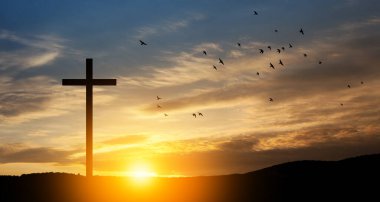 Christian cross on hill outdoors at sunrise. Resurrection of Jesus. Concept photo.