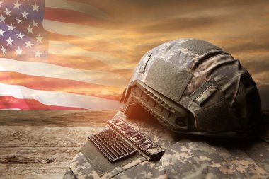 USA military uniform with insignias on old wooden table on sunset sky background with USA flag. Memorial Day or Veterans day concept.