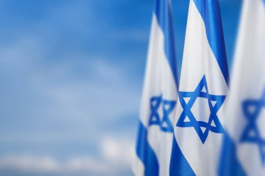 Bulutlu arka planda David 'in yıldızıyla İsrail bayrakları. Ulusal devlet sembolleriyle İsrail hakkında vatansever bir kavram. Metin için yeri olan pankart.