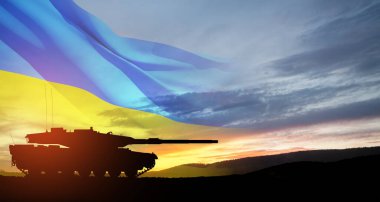Silhouette of army tank at sunset sky background with Ukrainian flag. Shipping a huge, wide-ranging package of heavy weapons to Ukraine.