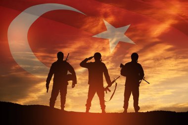 Silhouettes of soldiers on a background of Turkey flag and the sunset or the sunrise. Concept of crisis of war and conflicts between nations. Greeting card for Turkish Armed Forces Day, Victory Day.