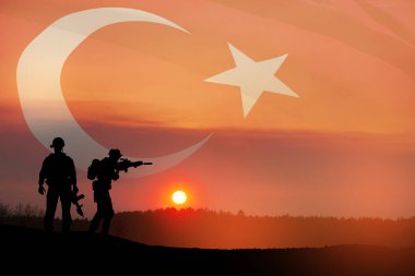 Silhouettes of soldiers on a background of Turkey flag and the sunset or the sunrise. Concept of crisis of war and conflicts between nations. Greeting card for Turkish Armed Forces Day, Victory Day.