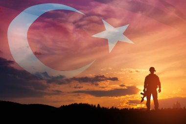 Silhouette of soldier on a background of Turkey flag and the sunset or the sunrise. Concept of crisis of war and conflicts between nations. Greeting card for Turkish Armed Forces Day, Victory Day.