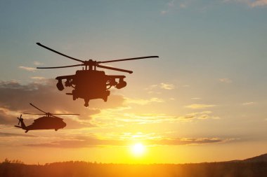 Gün batımının arka planında helikopter siluetleri. Gaziler Günü için tebrik kartı, Anma Günü, Hava Kuvvetleri Günü. ABD kutlaması.