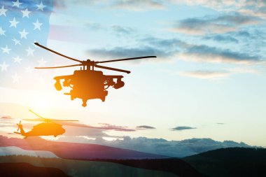 Gün batımının arka planında, şeffaf bir Amerikan bayrağı taşıyan helikopter siluetleri. Gaziler Günü için tebrik kartı, Anma Günü, Hava Kuvvetleri Günü. ABD kutlaması.