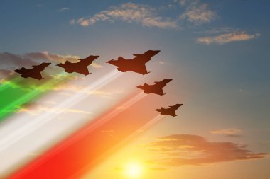 Gün batımının arka planında bayrak rengi izleri olan uçak siluetleri. Hava Kuvvetleri Günü. 28 Mart, İtalyan Hava Kuvvetleri.