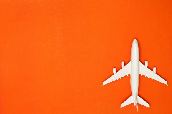 飛行機モデル オレンジの背景に白い飛行機 旅行休暇のコンセプト 夏の背景 フラットレイアウト トップビュー コピースペース — ストック写真