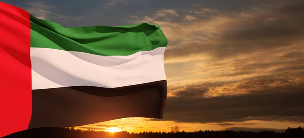 stock image Flag of United Arab Emirates on background of sunset sky. UAE celebration. National day, Flag day, Commemoration day, Martyrs day. Banner with place for text.