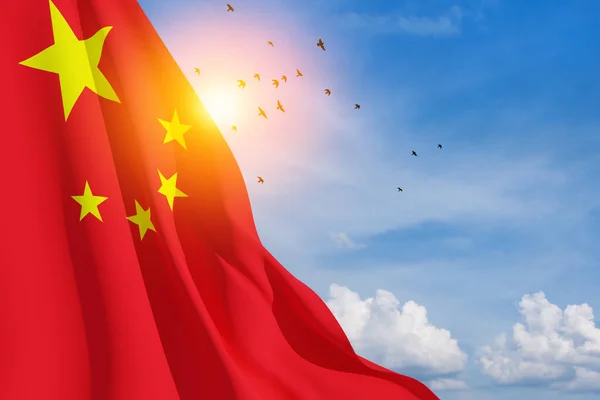 Close up waving flag of China on background of blue sky with flying birds. Flag symbols of China. National day of the people\'s republic of China. 1st october. 3d rendering.