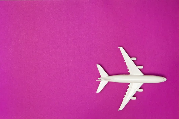 飛行機モデル 紫色の背景に白い飛行機 旅行休暇のコンセプト 夏の背景 フラットレイアウト トップビュー コピースペース — ストック写真