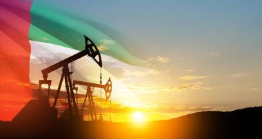 The change in oil prices caused by the war. Oil prices are rising because of the global crisis. Oil drilling derricks at desert oilfield with UAE flag. Crude oil production from the ground.