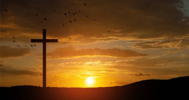 Christian cross on hill outdoors at sunrise. Resurrection of Jesus. Concept photo.