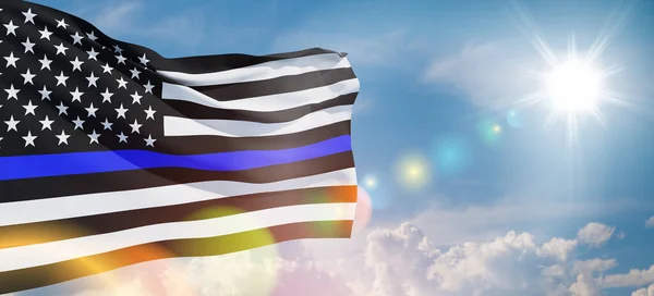 American flag with police support symbol Thin blue line on blue sky. American police in society as the force which holds back chaos, allowing order and civilization to thrive. Banner.