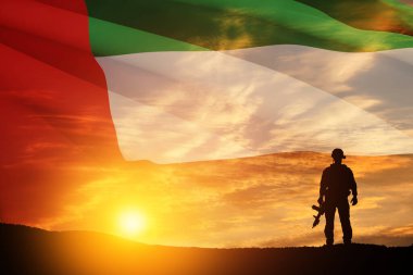 BAE bayrağının ve gün batımının ya da güneşin doğuşunun arkasındaki asker silueti. Ulusal tatil kavramı. Anma Günü.