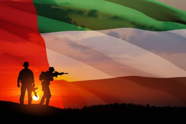 BAE bayrağının ve gün batımının ya da güneşin doğuşunun arkasındaki asker siluetleri. Ulusal tatil kavramı. Anma Günü.
