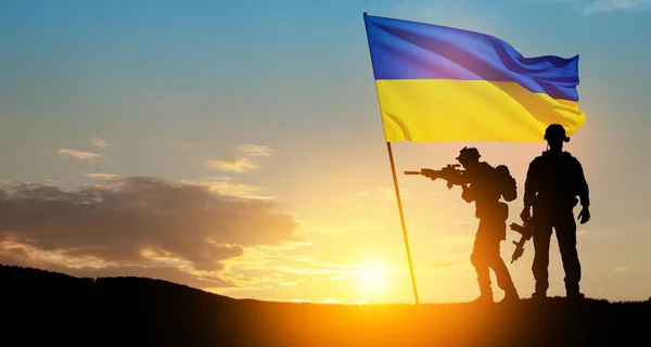 stock image Flag of Ukraine with silhouette of soldiers against the sunrise or sunset. Concept - armed forces of Ukraine. Relationship between Ukraine and Russia.