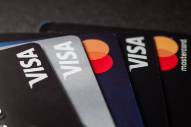 Visa kredi kartlarının ve kredi kartlarının yakın çekimleri koyu bir arkaplana yerleştirilmiş. Makro fotoğraf. Moskova, Rusya - 14 Mart 2022.