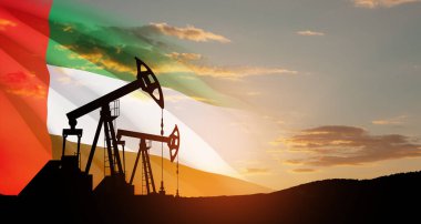 The change in oil prices caused by the war. Oil prices are rising because of the global crisis. Oil drilling derricks at desert oilfield with UAE flag. Crude oil production from the ground.