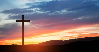 Christian cross on hill outdoors at sunrise. Resurrection of Jesus. Concept photo.