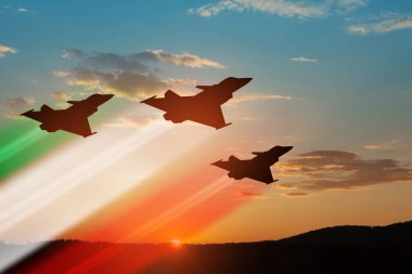 Gün batımının arka planında bayrak rengi izleri olan uçak siluetleri. Hava Kuvvetleri Günü. 28 Mart, İtalyan Hava Kuvvetleri.