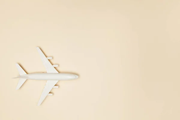 飛行機モデル ライトブラウンの背景に白い飛行機 旅行休暇のコンセプト 夏の背景 フラットレイアウト トップビュー コピースペース — ストック写真