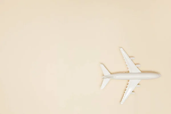 飛行機モデル ライトブラウンの背景に白い飛行機 旅行休暇のコンセプト 夏の背景 フラットレイアウト トップビュー コピースペース — ストック写真