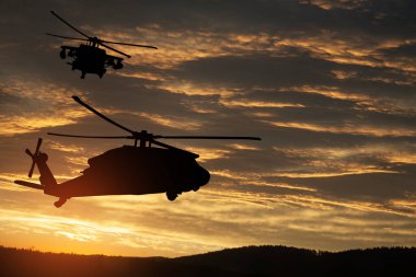 Gün batımının arka planında helikopter siluetleri. Gaziler Günü için tebrik kartı, Anma Günü, Hava Kuvvetleri Günü. ABD kutlaması.