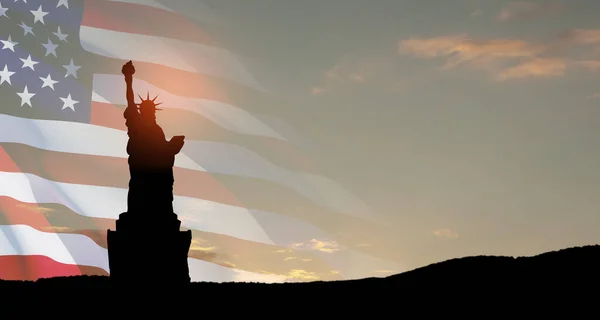 stock image Statue of Liberty with a large american flag and sunset sky on background. Greeting card for Independence Day. USA celebration.