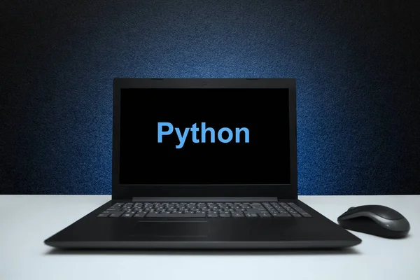Python text on laptop screen on textured black background with blue light. Learn swift programming language, computer courses, training.