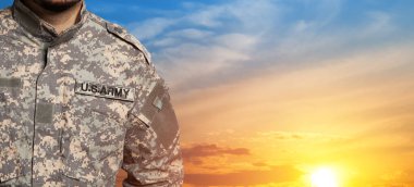 USA soldier in uniform on sunset sky background. Memorial Day or Veterans day concept.