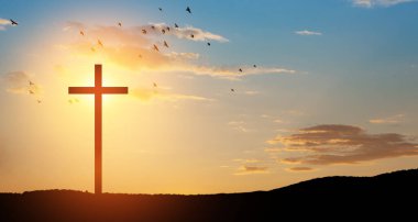 Christian cross on hill outdoors at sunrise. Resurrection of Jesus. Concept photo.