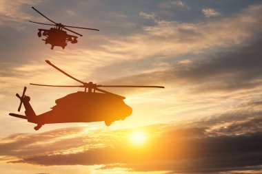 Gün batımının arka planında helikopter siluetleri. Gaziler Günü için tebrik kartı, Anma Günü, Hava Kuvvetleri Günü. ABD kutlaması.