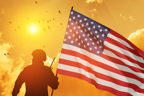stock image Silhouettes of soldier with USA flag against the backdrop of a sunset. Greeting card for Veterans Day, Memorial Day, Independence Day. USA celebration. Patriotism, protection, remember honor.