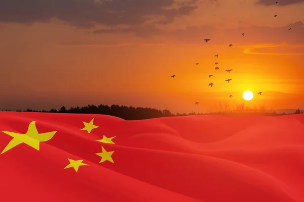 Close up waving flag of China on background of sunset sky with flying birds. Flag symbols of China. National day of the people\'s republic of China. 1st October.