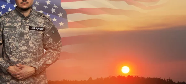 日没の空を背景にアメリカの兵士の制服を着て 米国のフラグです 記念日又は退役軍人の日の概念 — ストック写真
