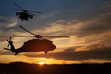 Gün batımının arka planında helikopter siluetleri. Gaziler Günü için tebrik kartı, Anma Günü, Hava Kuvvetleri Günü. ABD kutlaması.