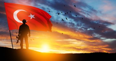 Gün batımında Türkiye bayrağı taşıyan asker silueti. Savaş krizi kavramı ve uluslar arasındaki siyasi çatışmalar. Türk Silahlı Kuvvetleri Günü için tebrik kartı, Zafer Günü.