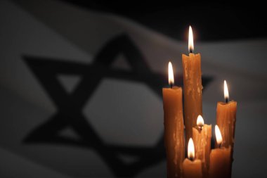 Six burning candles on Israel flag background. International Holocaust Remembrance Day, January 27.