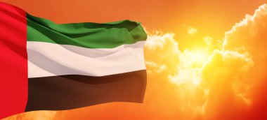 Flag of United Arab Emirates on background of sunset sky. UAE celebration. National day, Flag day, Commemoration day, Martyrs day. Banner with place for text.