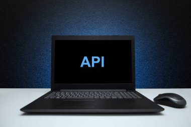 Dizüstü bilgisayardaki API metni mavi ışıkla desenli siyah arkaplan üzerine. Yazılım geliştirme