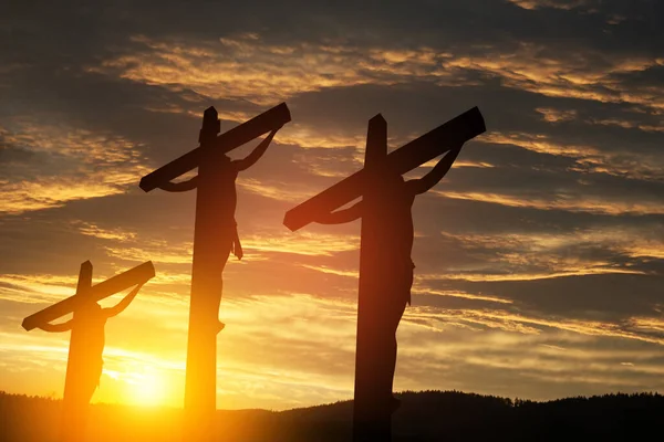 十字架につけられたイエス キリストのシルエットは 日没の空を背景に他の人々と共に — ストック写真