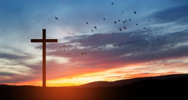Christian cross on hill outdoors at sunrise. Resurrection of Jesus. Concept photo.