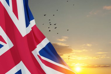 National flags of United Kingdom with flying birds on sunset sky background. Background with place for your text. 3d rendering.