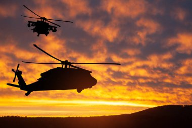 Gün batımının arka planında helikopter siluetleri. Gaziler Günü için tebrik kartı, Anma Günü, Hava Kuvvetleri Günü. ABD kutlaması.