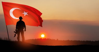 Gün batımında Türkiye bayrağı taşıyan asker silueti. Savaş krizi kavramı ve uluslar arasındaki siyasi çatışmalar. Türk Silahlı Kuvvetleri Günü için tebrik kartı, Zafer Günü.