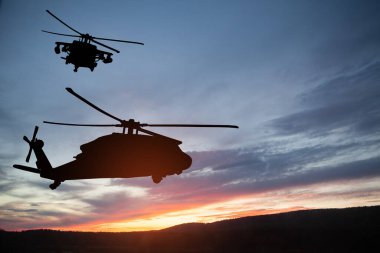 Gün batımının arka planında helikopter siluetleri. Gaziler Günü için tebrik kartı, Anma Günü, Hava Kuvvetleri Günü. ABD kutlaması.