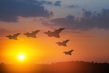 Hava Kuvvetleri Günü. Gün batımının veya güneşin doğuşunun arka planında uçak siluetleri.