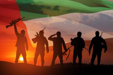 BAE bayrağının ve gün batımının ya da güneşin doğuşunun arkasındaki asker siluetleri. Ulusal tatil kavramı. Anma Günü.