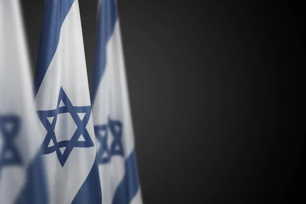 Israel flags with a star of David over dark gray background. Patriotic concept about Israel with national state symbols. Banner with place for text.